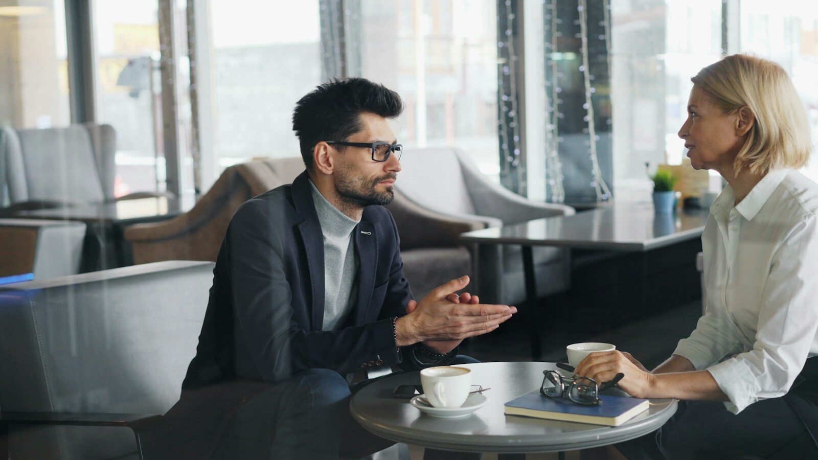 a man and a woman sitting at a table talking